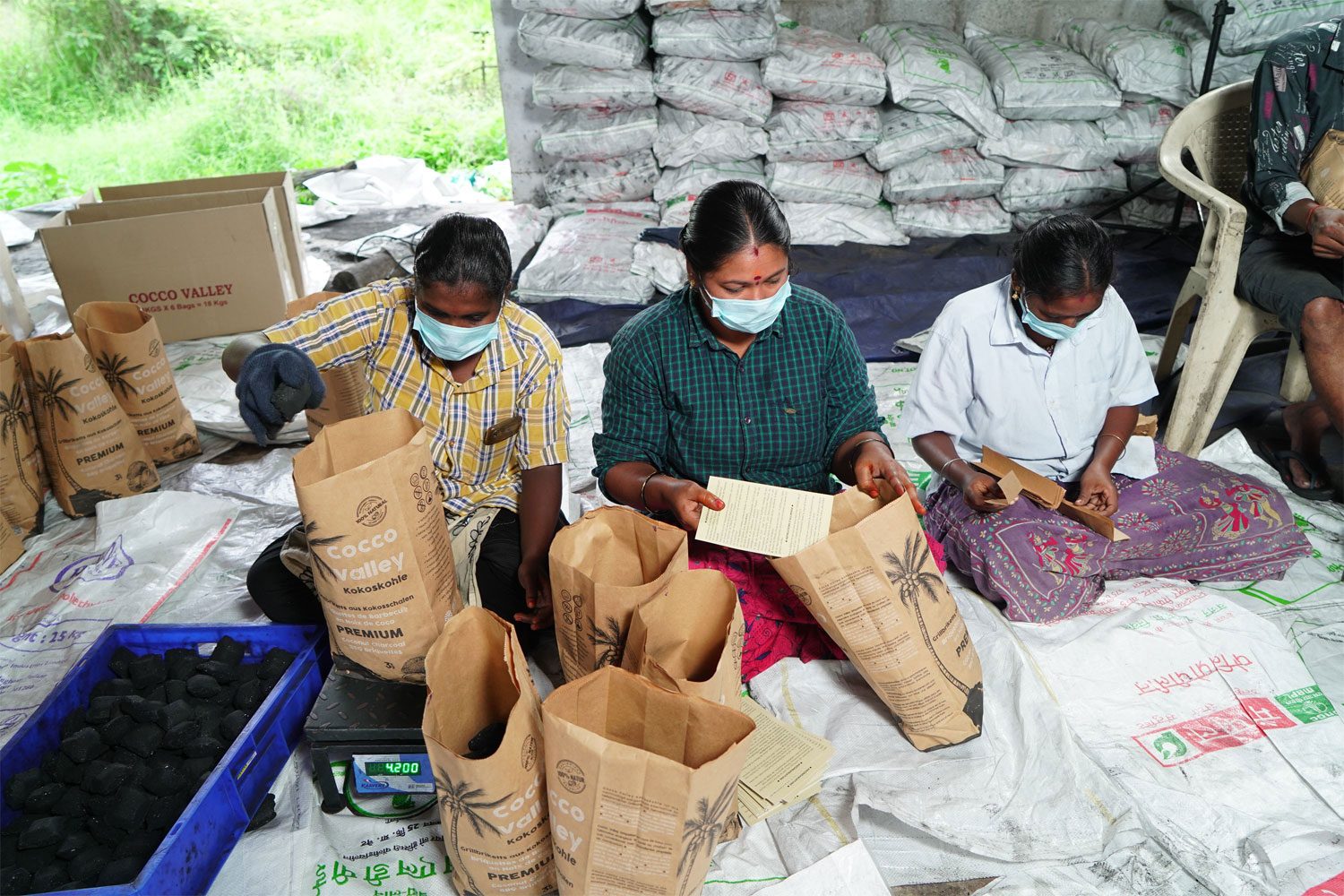 Women packing coconut shell charcoal